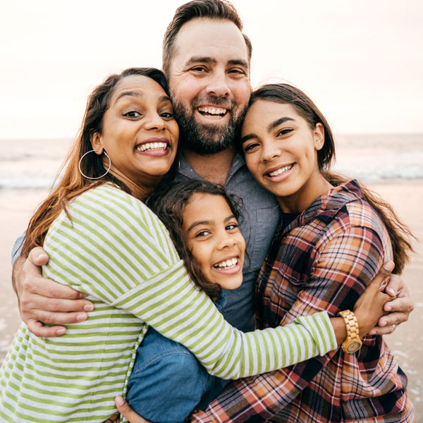smiling family of four on beach