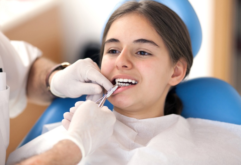 Dentist removing dental braces in Arlington Heights, IL