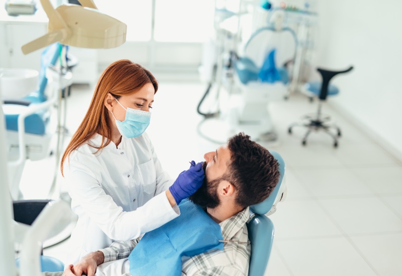 Dentist examining a patient's teeth for root canal in Antioch, IL