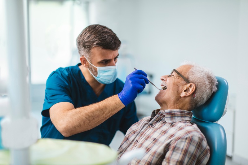 Senior patient receives dental exam in clinic in Arlington Heights, IL