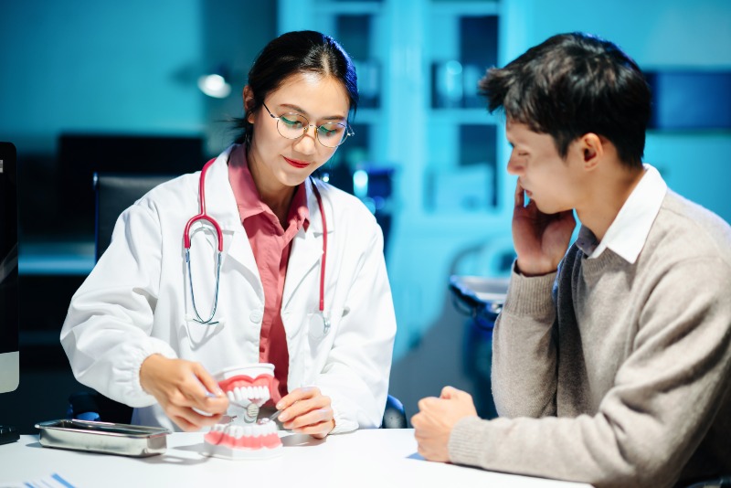 Dental professional discusses oral health using tooth model in Arlington Heights, IL